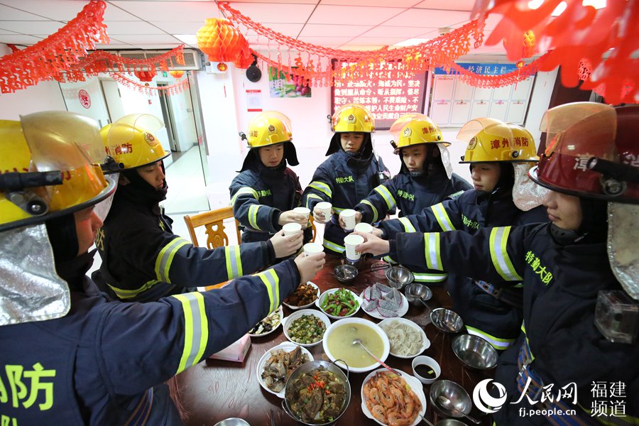 漳州消防特勤大隊一中隊消防指戰(zhàn)員歡聚一堂，吃年夜飯，舉杯共飲。