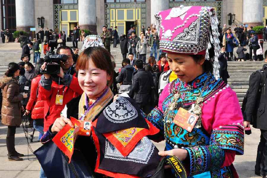 云南代表團的兩位女代表在為記者展示她們帶來的民族特色手工藝品。 人民網(wǎng)記者 馬麗婭 攝