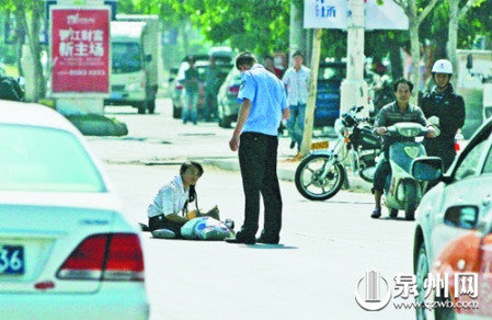 女孩從摩的上摔下，跌坐路中央，恰遇社區(qū)聯(lián)防巡邏人員扶起。