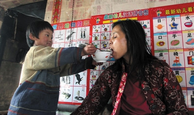 小孫悅為臥床的母親喂飯。